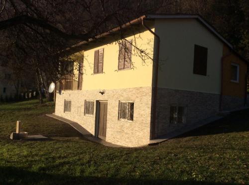 un bâtiment blanc avec une porte dans un champ dans l'établissement Ferienhaus In Steindorf Am Ossiacher See, à Steindorf am Ossiacher See