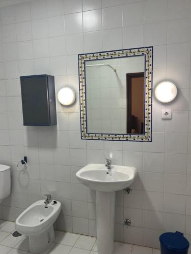 un bagno con lavandino, specchio e WC di Casa dos Assentos a Quintiães