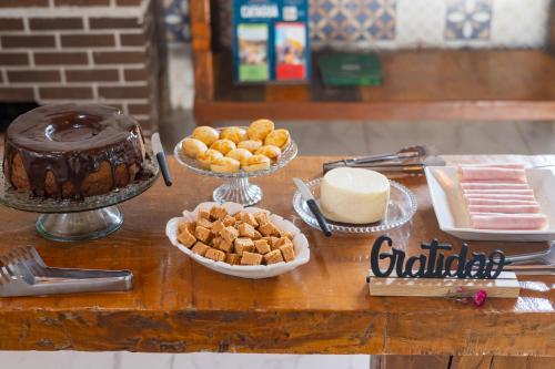 Pousada Império de Minas في كابيتوليو: طاولة مليئة بكعكة الشوكولاته والحلويات الأخرى