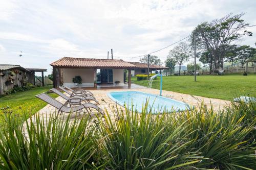 uma casa com piscina no quintal em Pousada Império de Minas em Capitólio