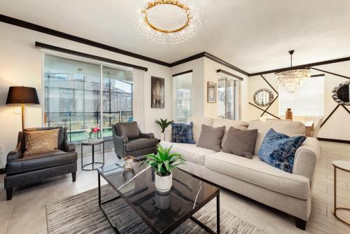 a living room with a couch and a table at New Beautiful 7 br w pool games theme rooms in Kissimmee