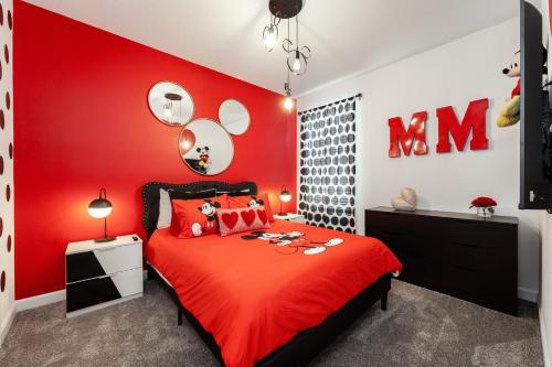 a red bedroom with a bed with a red headboard at New Beautiful 7 br w pool games theme rooms in Kissimmee
