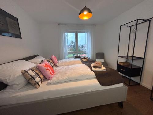 a bedroom with a bed with pillows and a window at Ferienwohnung Karma in Kressbronn am Bodensee