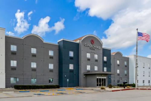a building with an american flag in front of it at Candlewood Suites Victoria by IHG in Victoria