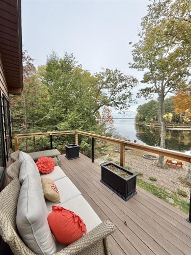 a porch with a couch and a view of the water at NORTHWEST EAGLE NEST LIMIT 9 home in East Sebago