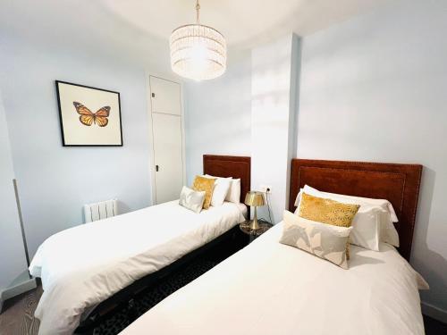two beds in a bedroom with a butterfly on the wall at Pradollano LUXUS Grandes vistas in Sierra Nevada