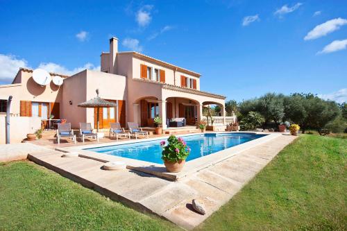 eine Villa mit einem Swimmingpool vor einem Haus in der Unterkunft Finca Can Marines in Calonge