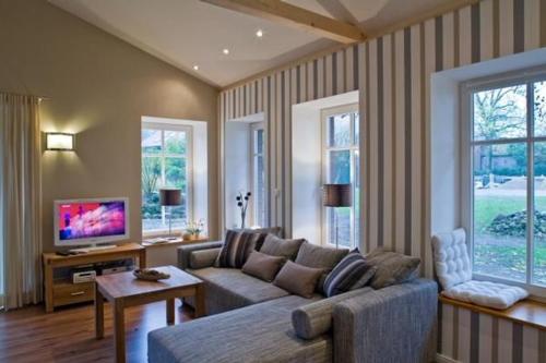ein Wohnzimmer mit Sofa und Fernseher in der Unterkunft Appartement in Klein Meckelsen mit Eigener Terrasse - b43026 in Klein Meckelsen