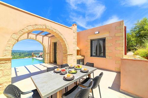 eine Terrasse mit Tisch und Stühlen und einem Pool in der Unterkunft Ferienhaus für 8 Personen ca 120 qm in Vafes, Kreta West-Kreta in Vafés