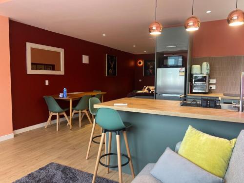 eine Küche und ein Wohnzimmer mit einer Theke und Stühlen in der Unterkunft El Gran - Quiet, Central & Scenic Apartment in Wanaka