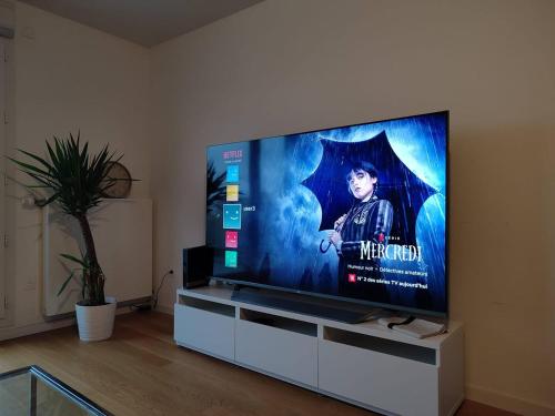 einen Flachbild-TV auf einem Stand in einem Wohnzimmer in der Unterkunft Penthouse Room - Ensuite - Terrace - Near Parc Expo & Airports in Bagneux