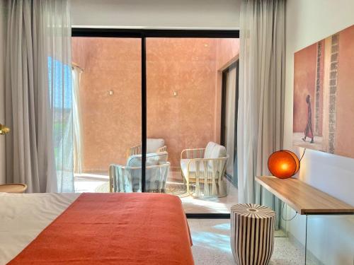 a bedroom with a bed and a table and chairs at Villa AYA - Moderne & Chic in Sraghna