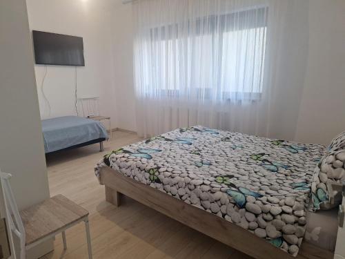 a small bedroom with a bed and a window at Apartament Sos Alexandriei Bragadiru in Bragadiru