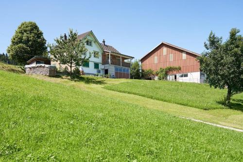 une maison au sommet d'une colline herbeuse dans l'établissement Hof Höchi, à Bruggen