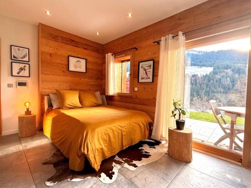 a bedroom with a bed and a large window at CHALET LYOBA in Le Grand-Bornand