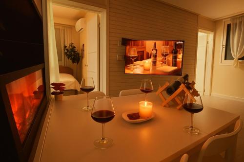 une table avec des verres de vin et une cheminée dans l'établissement 달빛그리기Moonlight, à Daegu