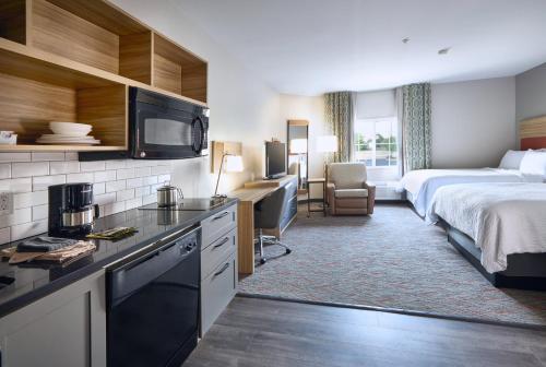 a hotel room with a kitchen and a bed and a room at Candlewood Suites Hot Springs by IHG in Hot Springs