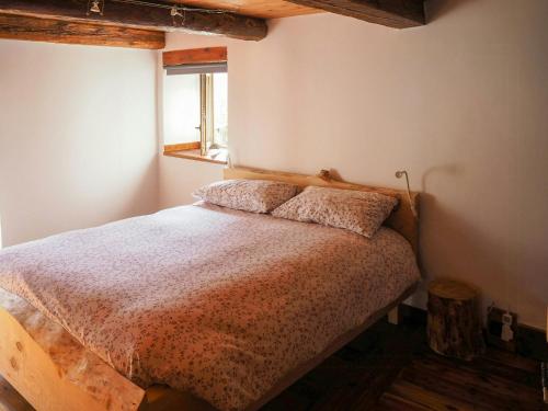 ein Schlafzimmer mit einem Bett und einem Fenster in der Unterkunft Stone Mountain Cabin Overlooking Ala Valley in Alo di Stura