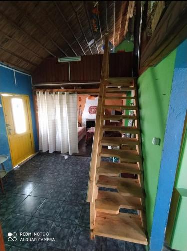 eine Holztreppe in einem Zimmer mit einem Bett in der Unterkunft De Sol a Sol in Barra de Valizas