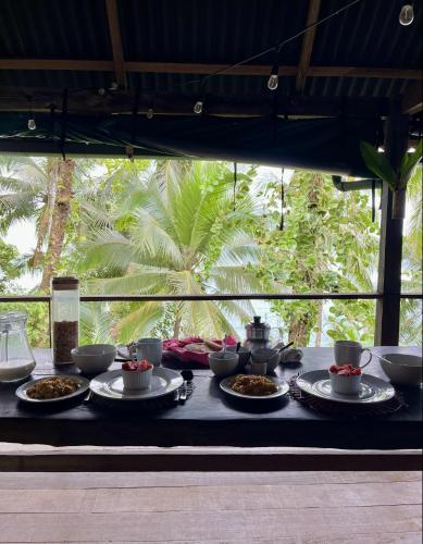 a table with bowls and plates of food on it at Punta Brava in Nuquí