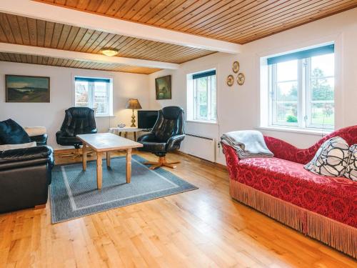 a living room with a red couch and chairs at 5 person holiday home in Rømø in Toftum