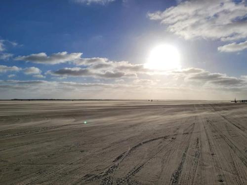 an empty field with the sun in the sky at 5 person holiday home in Rømø in Toftum