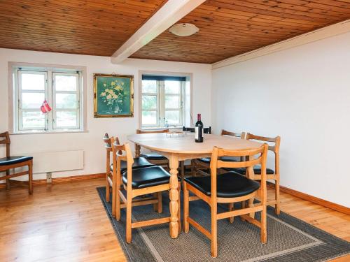 a dining room with a wooden table and chairs at 5 person holiday home in Rømø in Toftum