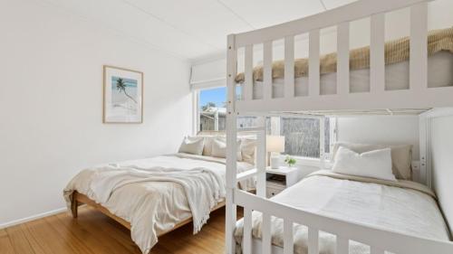 een slaapkamer met twee stapelbedden en een raam bij La Plage Portsea in Portsea