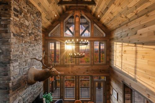 a room with a stone wall and a ceiling with a deer head on the wall at Sunset Mountain View - Indoor Pool - Luxury Lodge in Waldens Creek