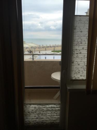 a view of a beach from a room with a window at First Line Apartment at Obzor in Obzor