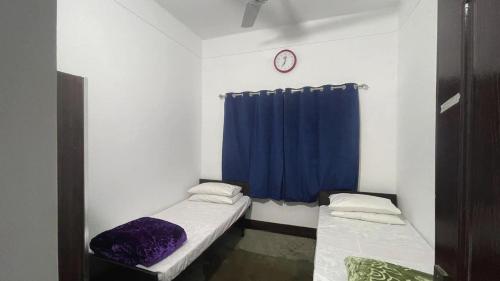 a room with two beds and a blue curtain at YMCA Girls Hostel, Mall Road, Lahore in Lahore