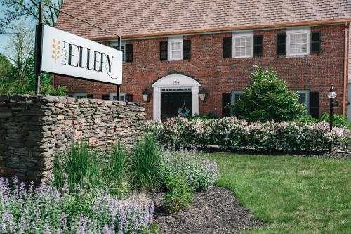a sign in front of a brick building with flowers at The Ellery in Northampton