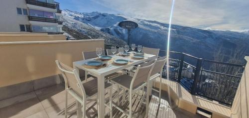a table and chairs on a balcony with a view at SnowGranada Los Valles Daniela House in Monachil
