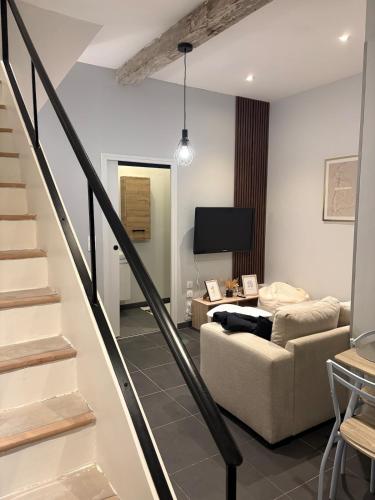 - un salon avec un canapé, une télévision et des escaliers dans l'établissement Duplex Haut de Gamme Centre Montauban, à Montauban