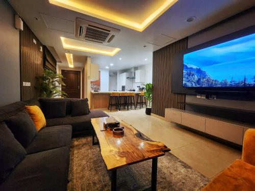 a living room with a large flat screen tv at Goldcrest Alfatah Mall - DHA Phase 4 - Luxury Apartments by Alvis Suite in Lahore