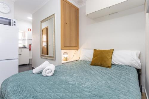 a bedroom with a bed with two towels on it at Maison Grise in Setúbal