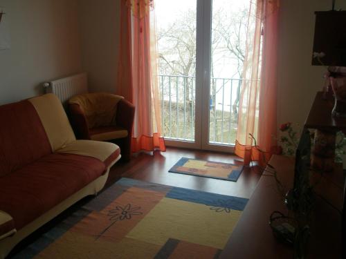 a living room with a couch and a window at Club218 Relax Family Apartman in Siófok