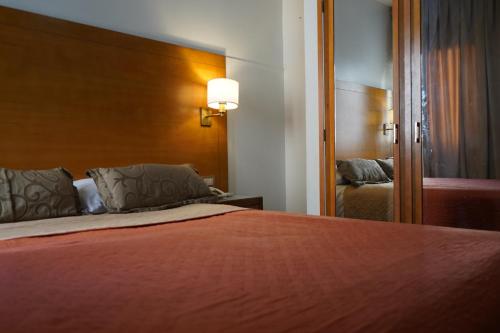 a bedroom with a large bed and a mirror at Hotel coventry in Santiago del Estero