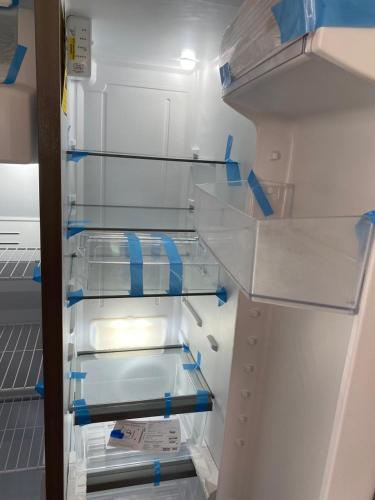 ein offener Kühlschrank mit blauem Klebeband an der Tür in der Unterkunft Monterrico Villa salida a Piscina y Jardin in Monterrico