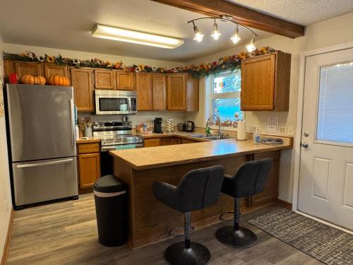 a kitchen with wooden cabinets and a stainless steel refrigerator at Northern Knights in Fairbanks