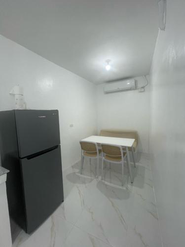 uma pequena cozinha com uma mesa e uma geladeira em Shalimar Bungalow House em Antipolo