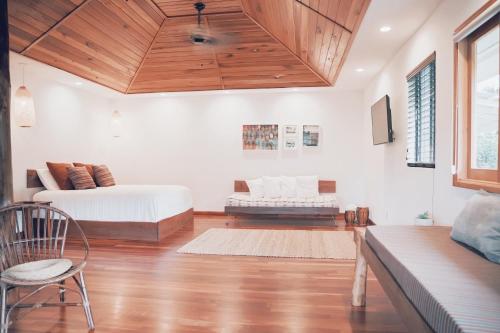 a bedroom with a bed and a wooden ceiling at Loi B&B in Hilo