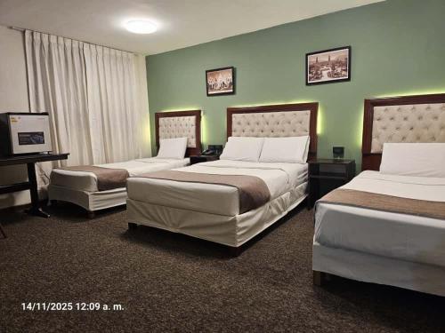 ein Hotelzimmer mit zwei Betten und zwei Stühlen in der Unterkunft Rivero 520 in Arequipa