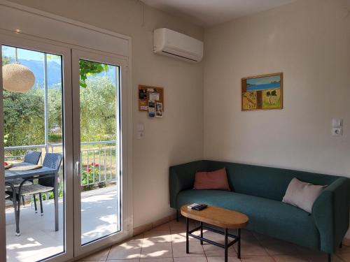 a living room with a green couch and a table at Ferienhaus In Thasos Mit Großer Terrasse in Potamia