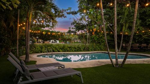 a swimming pool with two chairs and trees and lights at Modern Miami Oasis with Pool & Water View in North Miami