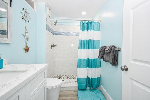 a bathroom with a blue and white shower curtain at Cedar Key Island Condo 228 in Cedar Key