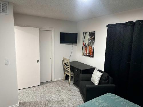 ein Schlafzimmer mit einem Schreibtisch, einem Stuhl und einem TV in der Unterkunft South Side Resort - Very Close Derby Turnpike Dtn in South Seneca Gardens