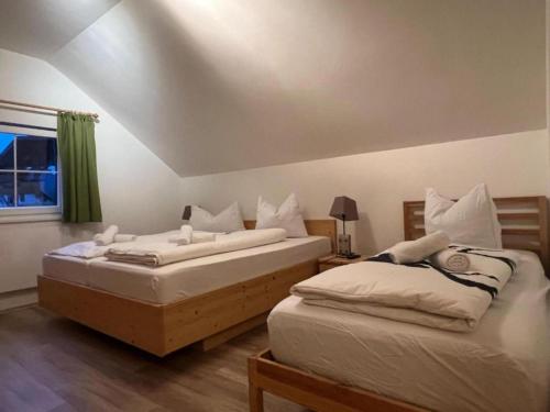 deux lits jumeaux dans une chambre avec fenêtre dans l'établissement Sauna Chalet Ahorn, à Staudach