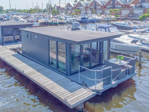 a small house on a dock in a marina at Tiny houseboat Parel I - airco in Uitgeest