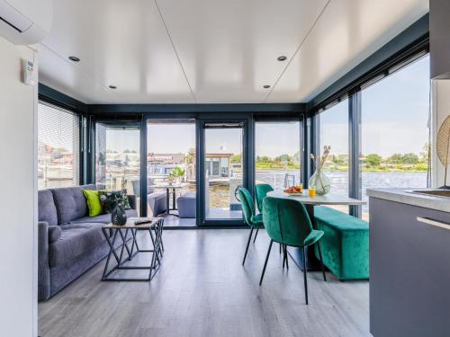 a living room with a couch and a table with chairs at Tiny houseboat Parel I - airco in Uitgeest